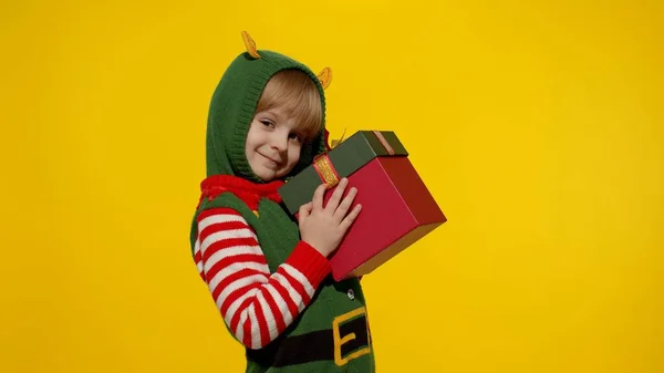 Дитяча дівчинка Різдвяний ельф Санта-помічник з подарунковою коробкою посміхається камері. Щасливі новорічні свята — стокове фото