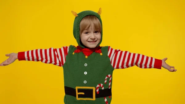 Дитяча дівчинка в різдвяному ельфійському костюмі Санта помічник танцює, обманюючи навколо. Святкування новорічних свят — стокове фото