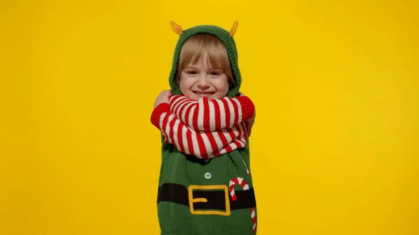 穿着圣诞精灵圣诞老人助手服装的年轻金发女孩微笑，调情，拥抱，拥抱 — 图库照片