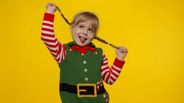 小女孩穿着圣诞精灵圣诞老人助手服装跳舞，鬼鬼祟祟。新年庆祝活动 — 图库照片