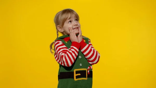Garota elfo de Natal Santa ajudante steepls dedos esperando por caixa de presente. Criança em feriados de Ano Novo — Fotografia de Stock