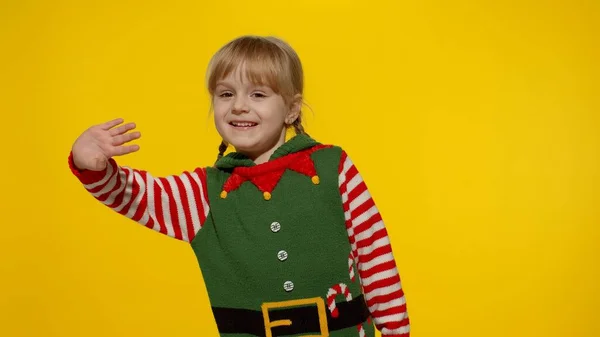 Девушка в костюме помощника рождественского эльфа Санты машет рукой. Элло, привет, жест приветствия — стоковое фото