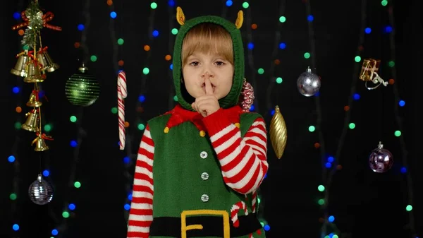 Дівча з різдвяного ельфа Санта Клаус костюм помічника тримаючи палець біля губ для тиші, тихий знак — стокове фото