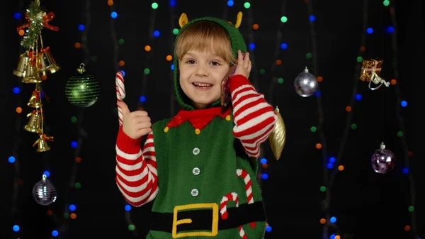 Маленька дівчинка з різдвяного ельфа Санта Клаус костюм помічника вітає телефонний дзвінок — стокове фото