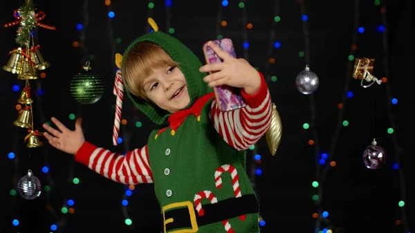 Дівча з різдвяного ельфа Санта Клауса костюм помічника робить селфі на смартфоні. Новорічні канікули — стокове фото