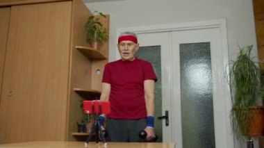 Yaşlı büyükbaba evde halterlerle, antrenmanlarla, spor faaliyetleriyle çalışıyor.