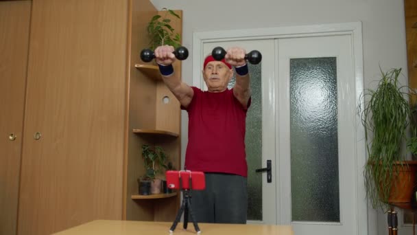Gepensioneerde senior man doet workout, training, fitness, sport-oefeningen tijdens het coronavirus — Stockvideo