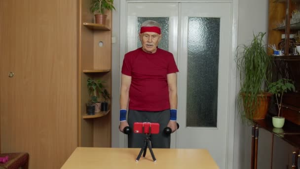 Volwassen paar man fitness trainer coach opnemen video online workout blog cursus met smartphone — Stockvideo