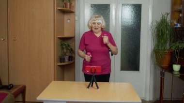 Olgun çift fitness antrenörü akıllı telefon ile video çevrimiçi çalışma bloğu kursu kaydediyor