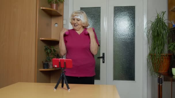 Anciana anciana abuela haciendo ejercicio con pesas, entrenamiento, fitness, actividad deportiva en casa — Vídeo de stock