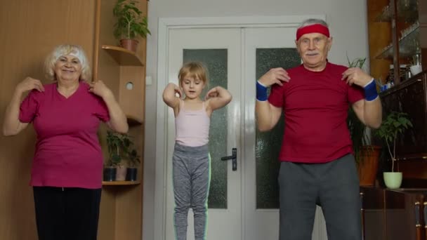 Vnučka a starší prarodiče ve sportovním oblečení, sportovní jogging cvičení doma — Stock video