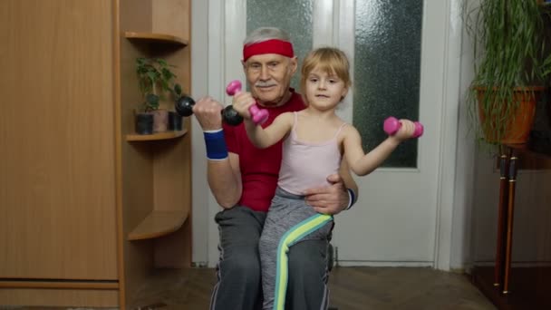 Avô ativo homem sênior com criança menina fazendo exercícios de levantamento de peso fitness com halteres — Vídeo de Stock