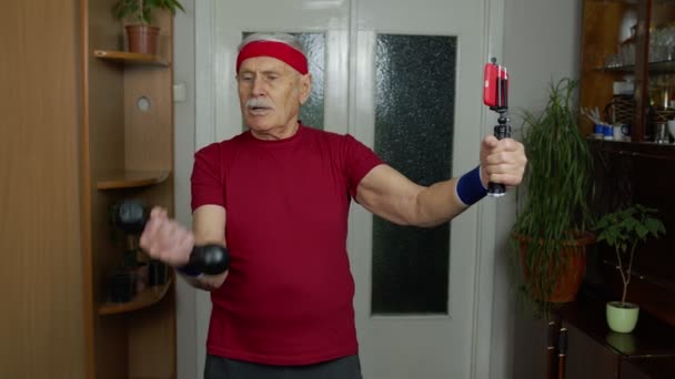 Старший дед занимается спортом с гантелями, тренировками, фитнесом, спортом дома — стоковое видео
