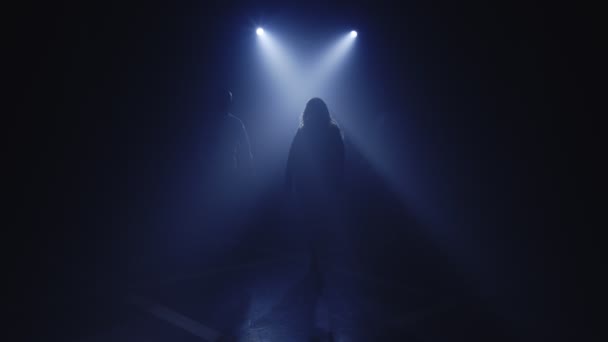 Backlit silhouettes of singer vocalist girl, saxophonist sax, dj man with headphones walking forward — Stock Video