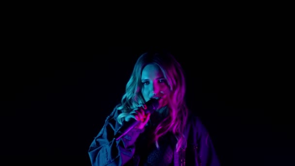 Desempenho vocal ao vivo do cantor na escuridão, vocalista bonito menina em neon dança luz, cantando — Vídeo de Stock