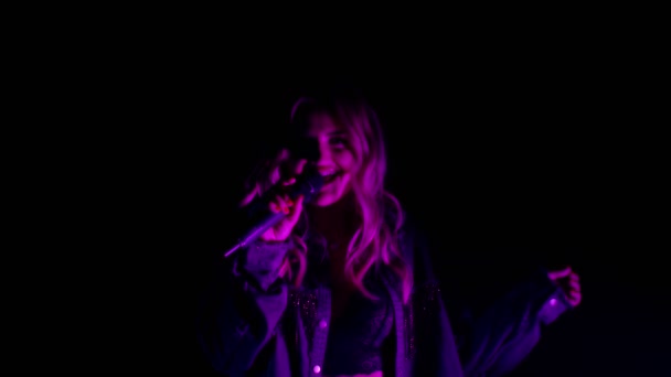 Spettacolo vocale dal vivo di cantante nel buio, cantante ragazza carina in danza luce al neon, canto — Video Stock