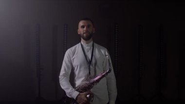 Saksafoncunun canlı performansı, saksafoncu adam, konser müzisyeninin sahnesinde ışıklarla dans ediyor.