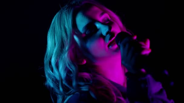 Penampilan vokal live penyanyi dalam kegelapan, vokalis gadis lucu di neon cahaya menari, bernyanyi — Stok Video