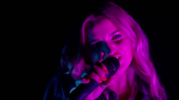 Desempenho vocal ao vivo do cantor na escuridão, vocalista bonito menina em neon dança luz, cantando — Vídeo de Stock