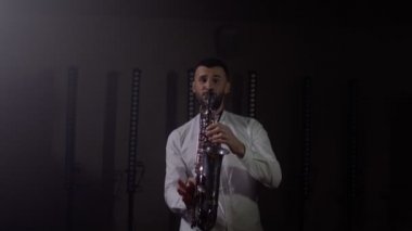 Saksafoncunun canlı performansı, saksafoncu adam, konser müzisyeninin sahnesinde ışıklarla dans ediyor.