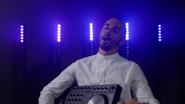 Actuación DJ en vivo del calvo enérgico con controlador de mezclador, bailando en el escenario del músico de concierto — Vídeo de stock