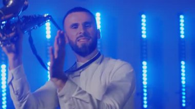 Saksafoncunun canlı performansı, saksafoncu adam, konser müzisyeninin sahnesinde ışıklarla dans ediyor.