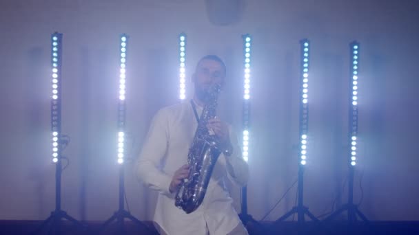 Actuación en vivo del saxofonista hombre con saxofón, bailando en concierto músico escenario con luces — Vídeo de stock