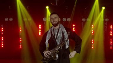Saksafoncunun canlı performansı, saksafoncu adam, konser müzisyeninin sahnesinde ışıklarla dans ediyor.