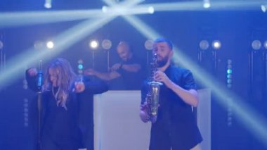 Müzik çalan üç kişilik müzik grubu, konser müzisyenlerinin ışık sahnesinde sahne alacaklar.