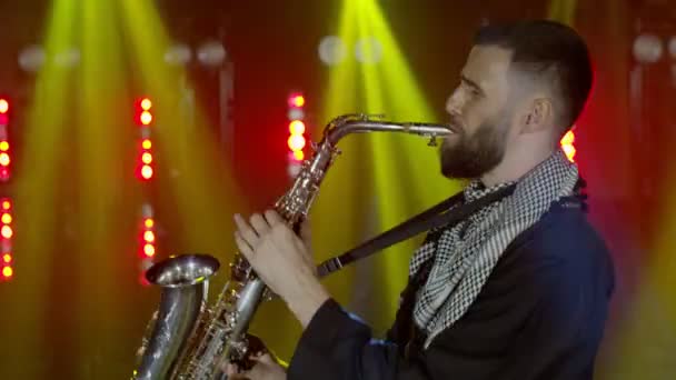 Performance ao vivo do homem saxofonista com saxofone, dançando no palco do músico de concerto com luzes — Vídeo de Stock