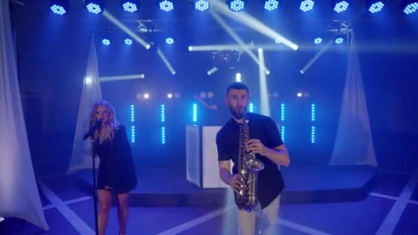 Musikgrupp band av sångerska kvinna, saxofonist, dj man spelar musik sång, uppträda på scenen — Stockvideo
