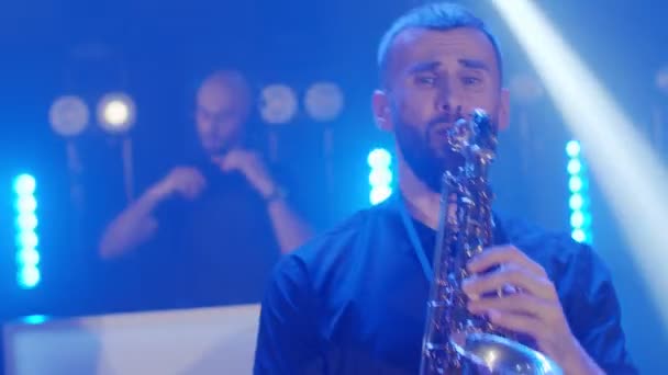 Spectacle live d'homme saxophoniste avec saxophone, danse sur scène de concert avec DJ — Video