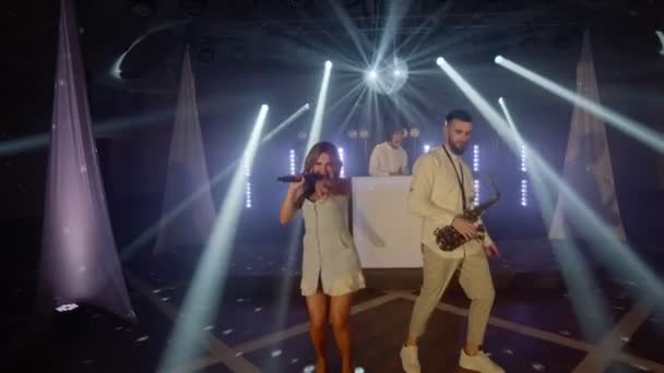 Şarkıcı kadın müzik grubu, saksafoncu, DJ şarkı söylüyor, sahnede şarkı söylüyor. — Stok video