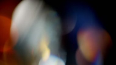 Işık sızıntısı 4K görüntüsü. Lens parlaklığı bokeh örtüleri, yanan alev arka planı. Flaş ışınları etkisi