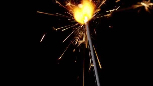 Bengala fogo luzes cintilantes queimando na frente de fundo preto, close-up imagens 4k, câmera lenta — Vídeo de Stock