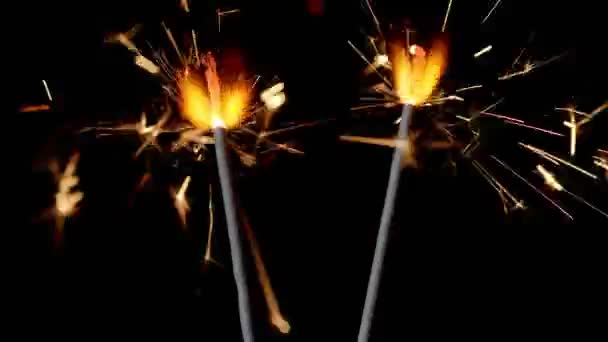 Bengal fires, New Year sparkler candles, sparkling lights burning on a black background, slow motion — Stock Video
