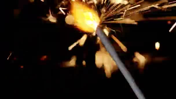 Bengálský oheň jiskřící světla hořící před černým pozadím, detailní záběry 4k, zpomalený pohyb — Stock video