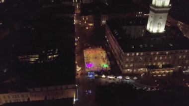 Lviv şehrinin Arial manzarası, Ukrayna Rynok meydanı, Noel panayırı, insanlar buz pateni pistinde kayıyor.