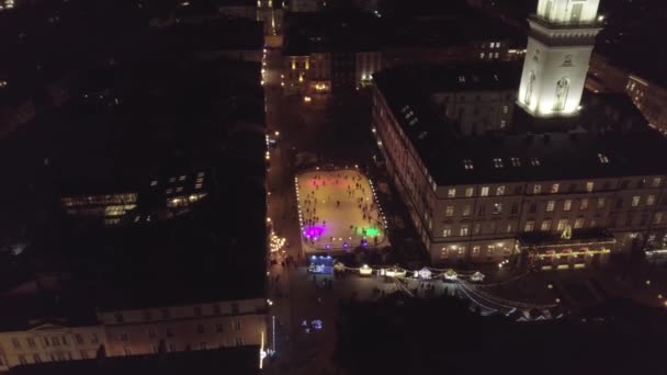 Vista arial della città Lviv, Ucraina Rynok piazza, Fiera di Natale, persone pattinare sulla pista di pattinaggio su ghiaccio — Video Stock