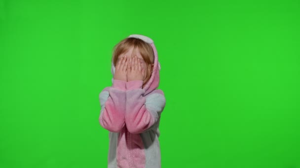 유니콘 의상을 입고 울고 있는 금발의 어린 아이가 크로마의 주요 배경 위에서 양손으로 눈물을 닦고 있다 — 비디오