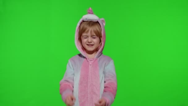 유니콘 의상을 입고 울고 있는 금발의 어린 아이가 크로마의 주요 배경 위에서 양손으로 눈물을 닦고 있다 — 비디오