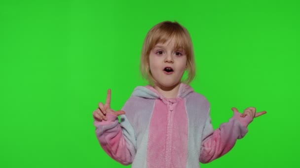Child girl in unicorn pajamas making silly funny faces, fooling around, showing tongue on chroma key — Stock Video