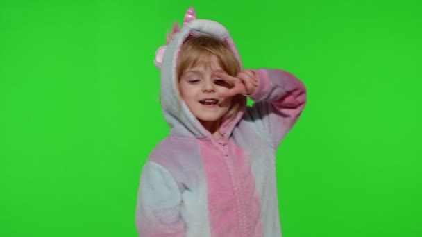 Petite fille blonde enfant souriant, dansant, célébrant en pyjama licorne costume sur clé chroma — Video