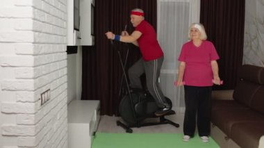Yörünge turu atan yaşlı bir çift evde ağırlık kaldırma egzersizi yapıyor.