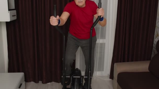 积极健康的老年男子穿着运动服，在家里用轨道滑翔机训练有氧运动 — 图库视频影像