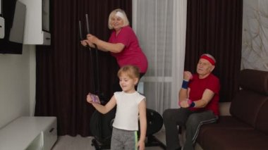 Üst düzey çift orbitrek kullanıyor, dambıl egzersizi yapıyor, çocuk kız cep telefonuyla selfie çekiyor.