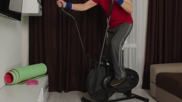 Ativo saudável idoso maduro homem no sportswear usando orbitrek, treinamento cardio treino em casa — Vídeo de Stock