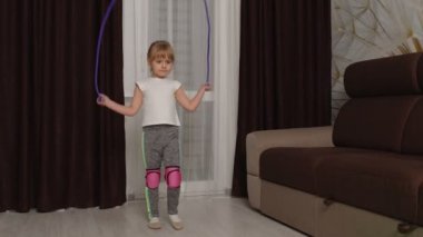 Spor egzersizleri yapan, evde dizüstü bilgisayarda video eğitimi alan bir kız.