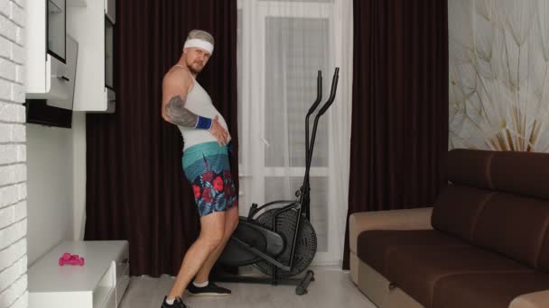 Esportista gordo engraçado cara sofá fazendo exercícios de cardio de corrida para perda de peso on-line vlog em casa — Vídeo de Stock