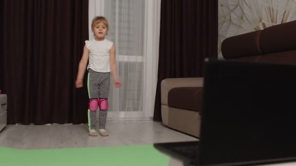 Barn flicka gör gymnastik fitness stretching träning hemma, video tutorial distansträning — Stockvideo